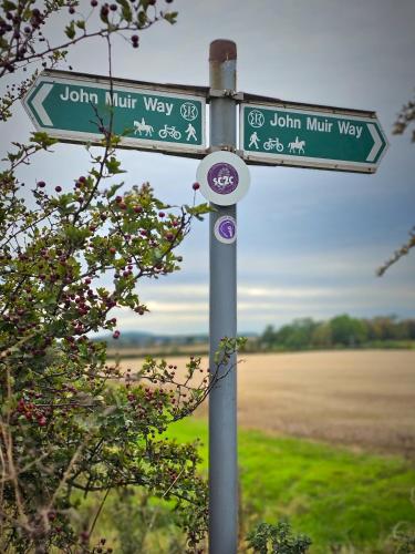 a street sign with two street signs on a pole at The Bonnie Wee Bothy in East Linton
