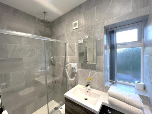 a bathroom with a sink and a shower and a sink at Melbury Rooms & Studios in Exeter