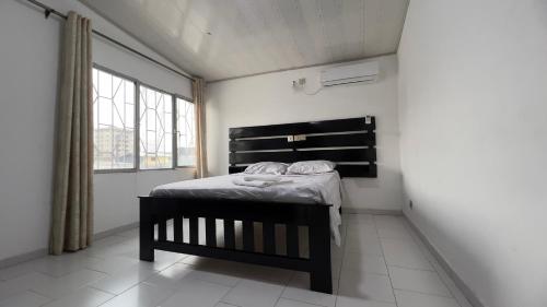 a bedroom with a bed in a room with a window at Résidence LCE in New Bell