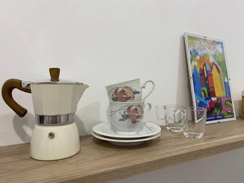 un mixeur sur une étagère avec une photo et des verres dans l'établissement Appartement cosy avec oasis privée, salle de jeux, vélos bienvenus, à Carcassonne