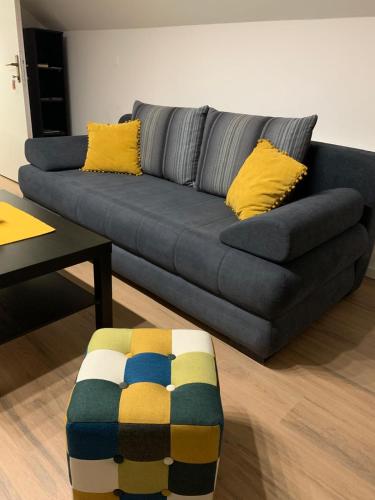 a blue couch with yellow pillows in a living room at Prenoćište Šimić in Slavonski Brod