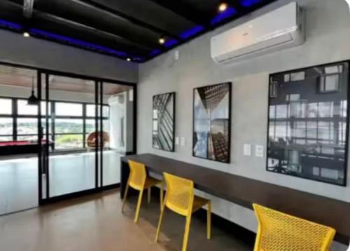a dining room with yellow chairs and a table at Apto alto padrao ao lado do IBIS - Av Esmeraldas in Marília