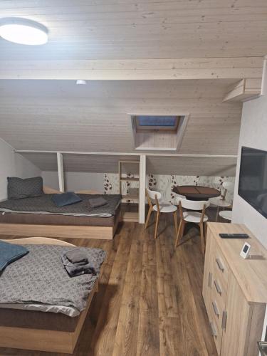 a room with two beds and a table and a tv at Lino butai number 3 in Kalviai