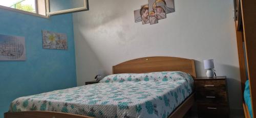 a bedroom with a bed with a comforter on it at Kenzia in Agnone Bagni