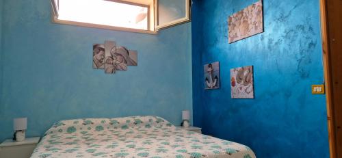 a bedroom with a blue wall with a bed at Kenzia in Agnone Bagni