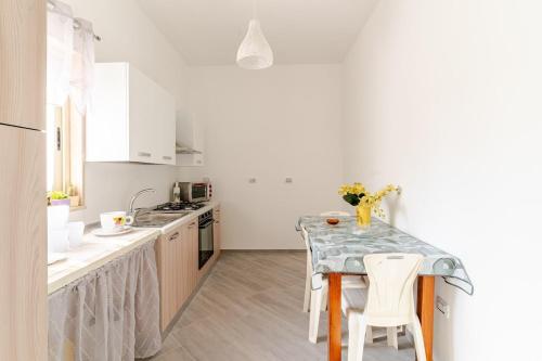 a white kitchen with a table and chairs in it at Villa Flaminio in Specchiolla 