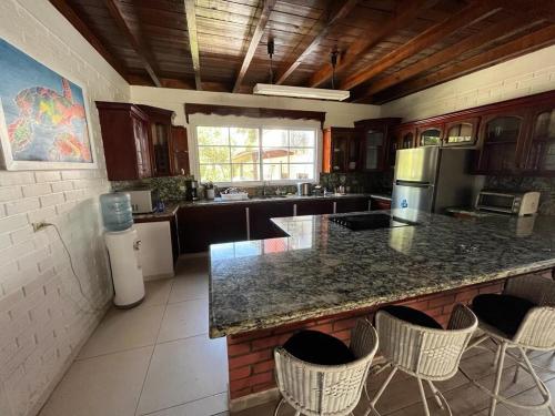 a kitchen with a counter and some chairs in it at Casa Carabela, Omoa, Cortes in Omoa
