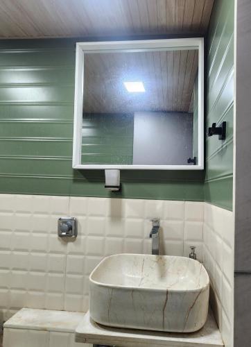 a sink in a bathroom with a mirror and a window at Cozy Vibes in Navi Mumbai