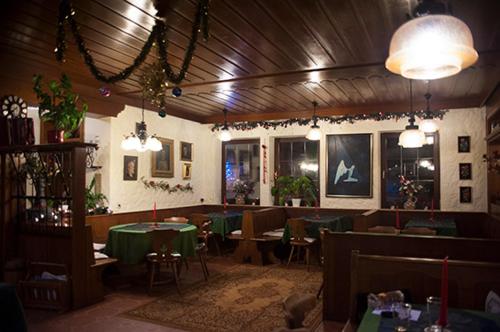 a restaurant with tables and chairs in a room at Pottensteiner Stuben Pension Gasthof in Pottenstein
