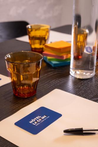 a table with a card and a glass on it at Hotel Locomo - Gare de Lyon Bastille in Paris