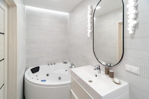 ヴィリニュスにあるapartment with jacuzzi, old townの浴槽、洗面台、鏡のあるバスルーム