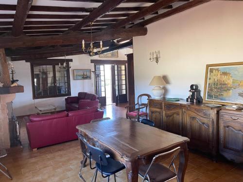 un salon avec une table et un canapé rouge dans l'établissement Villa très calme à la campagne, à Martigues
