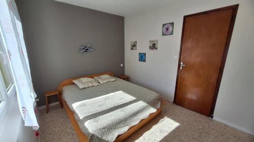 a small bedroom with a bed and a wooden door at L'apicasa de Bassan in Bassan
