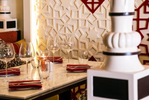 a table with wine glasses and a vase on it at Radisson Blu Resort & Thalasso Hammamet in Hammamet