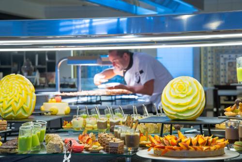 a chef in a kitchen with a buffet of food at Radisson Blu Resort & Thalasso Hammamet in Hammamet