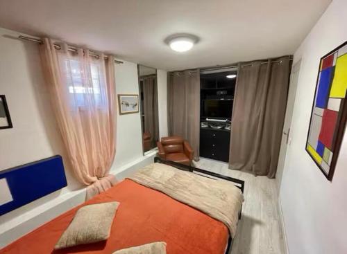 - une chambre avec un lit orange et une chaise dans l'établissement Chambre à 10 min de Paris, à Argenteuil