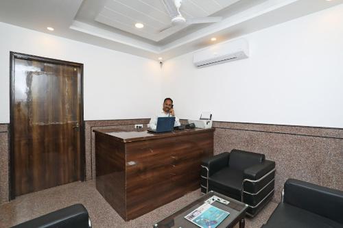 a man sitting at a desk in an office with a laptop at Hotel O Royal Stay in New Delhi
