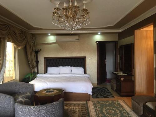 a bedroom with a large bed and a chandelier at Pyramid view! Sleeps 13 in Cairo