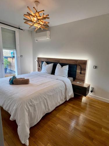 - une chambre avec un grand lit blanc et un lustre dans l'établissement Casa Jouvenel -T3 3 pers -Brive-Parking privatif, à Brive-la-Gaillarde