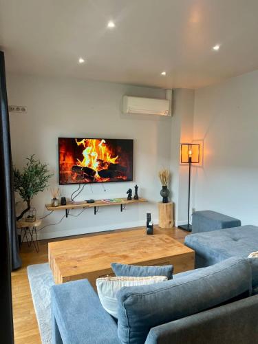 - un salon avec une cheminée au mur dans l'établissement Casa Jouvenel -T3 3 pers -Brive-Parking privatif, à Brive-la-Gaillarde