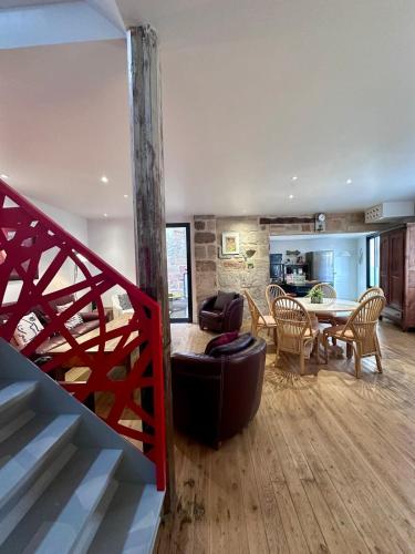- un salon avec un escalier, une table et des chaises dans l'établissement Atypique Loft avec Clim et Patio en Hyper Centre, à Brive-la-Gaillarde