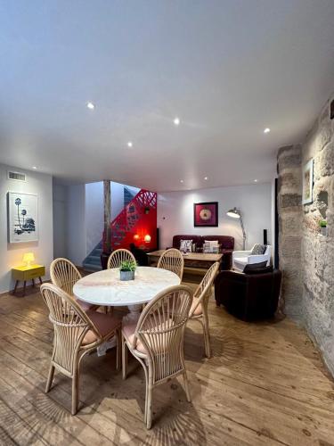 une salle à manger avec une table et des chaises et un salon dans l'établissement Atypique Loft avec Clim et Patio en Hyper Centre, à Brive-la-Gaillarde