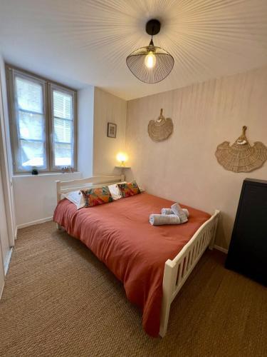 une chambre avec un grand lit avec une couverture rouge dans l'établissement Casa Jaubertie #2-T2 Bis chaleureux-Hyper Centre, à Brive-la-Gaillarde