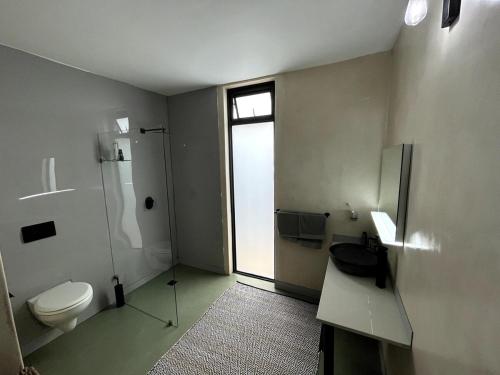 ein Badezimmer mit Toilette und Waschbecken und einem Fenster in der Unterkunft Scarbados Eco 1 Bed Seaside Cottage in Scarborough