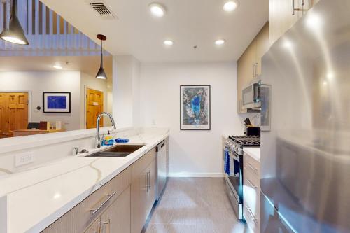 a large kitchen with white counter tops and appliances at Squaw Valley Ski Flat in Olympic Valley