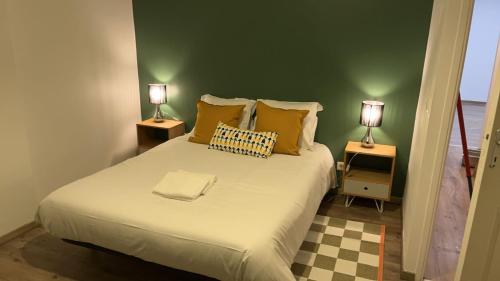 une chambre avec un lit avec deux lampes sur deux tables dans l'établissement Suite K, à Reims