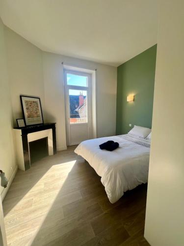 une chambre avec un lit blanc et une fenêtre dans l'établissement Casa Zola #2 - Grand T2 central avec balcon proche gare, à Brive-la-Gaillarde
