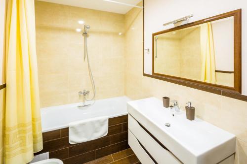 a bathroom with two sinks and a shower and a mirror at OK Apartments Lviv in Lviv