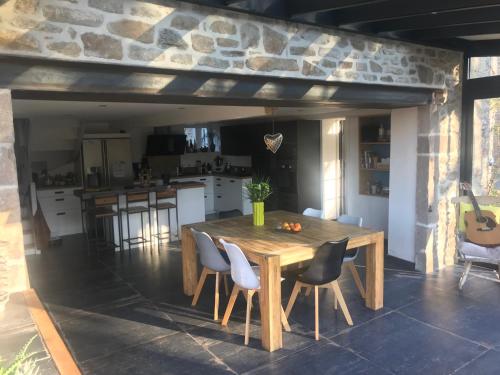 une cuisine avec une table en bois et quelques chaises dans l'établissement Chambres d'hôtes du Mont Roulet la Hague, à Auderville
