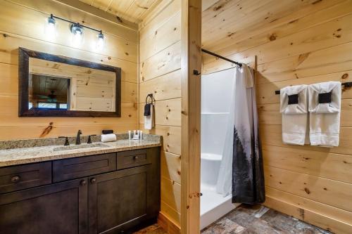 Un baño con ducha, lavabo y espejo. en Secluded Cabin Hot Tub, Game Room and Fireplace, en Pigeon Forge