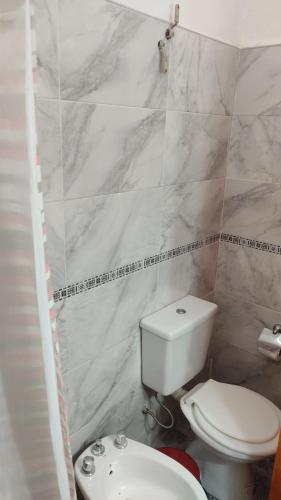 a bathroom with a white toilet and a sink at Cabañas los materos 2 in Córdoba