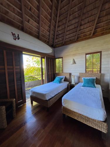 a bedroom with two beds and a wooden ceiling at Le Fare Tianee, Résidence Légends, BEST VIEW in Moorea