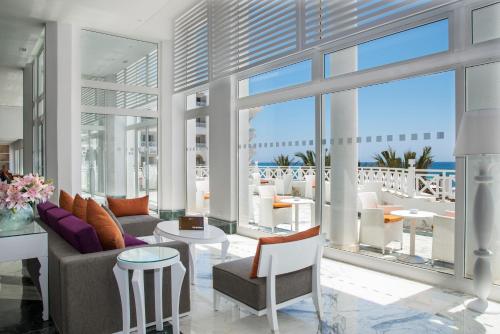 a living room with a couch and tables and windows at Radisson Blu Resort & Thalasso Hammamet in Hammamet