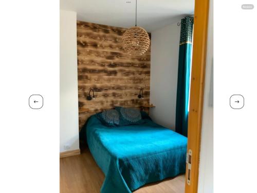 une chambre avec un lit bleu et un mur de briques dans l'établissement Maison de Ville, à Montignac