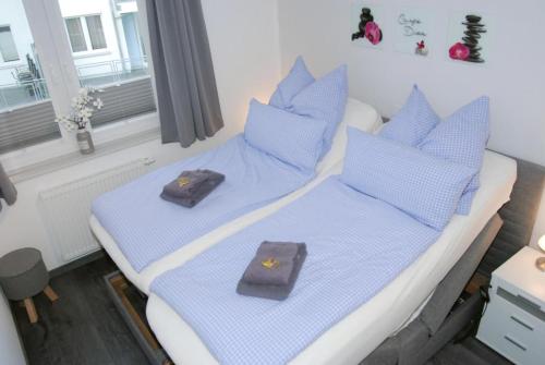 a bedroom with two beds with blue pillows at Meeresrauschen 6 in Großenbrode