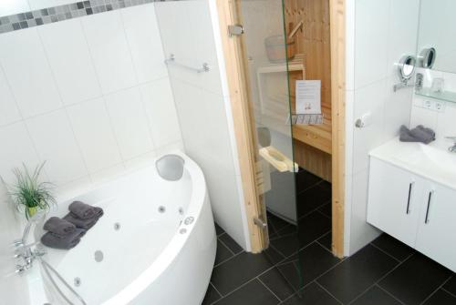 a bathroom with a tub and a toilet and a sink at Meeresrauschen 6 in Großenbrode