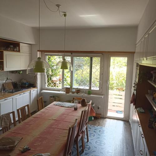 a kitchen with a table with chairs and a large window at Ripe's FoRest Garden Guest House in Rome