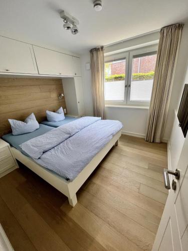 a bedroom with a large bed with blue sheets at Stranddüne im Achterhus in Juist
