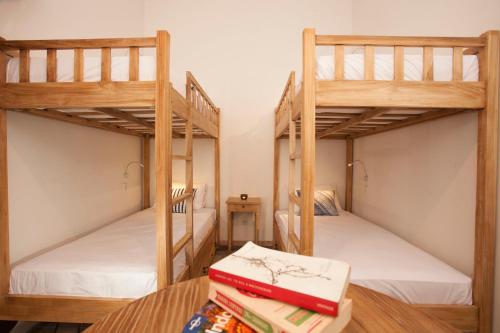 two bunk beds in a room with books on a table at Adhisthana Hotel Yogyakarta in Yogyakarta