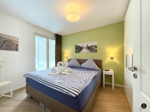 una camera da letto con un letto con un fiore bianco di Strandvilla Baabe 22 MEERESRAUSCHEN a Baabe
