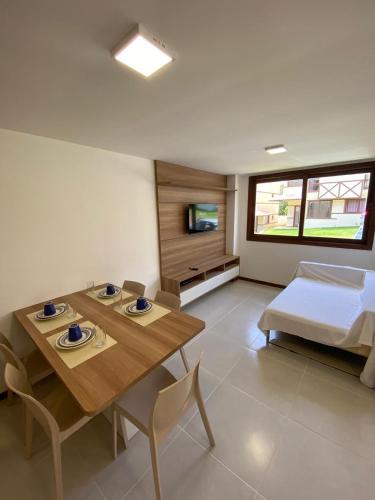 a living room with a table and a bed at Recanto Brisas de Imbassaí Village C18 in Mata de Sao Joao