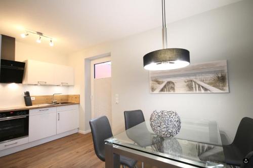 a kitchen and dining room with a glass table at Störtebeker 6 in Kellenhusen