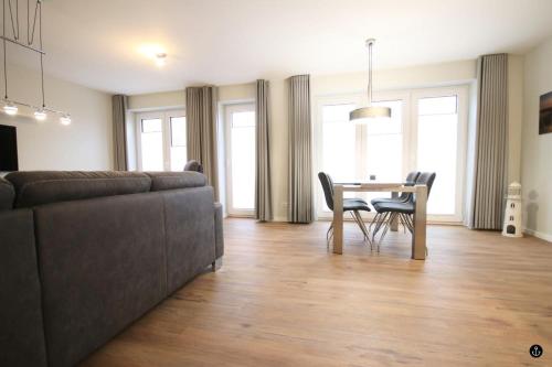 a living room with a couch and a table and chairs at Störtebeker 4 in Kellenhusen