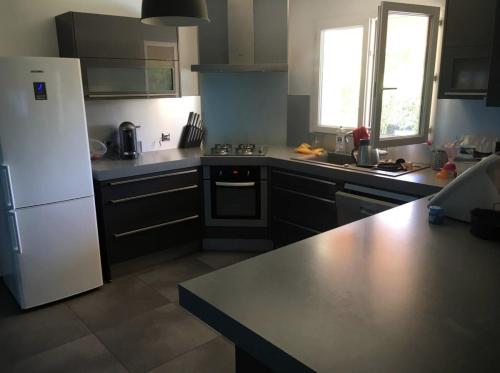 une cuisine avec un réfrigérateur blanc et un comptoir dans l'établissement Maison vacances, à Gallargues-le-Montueux