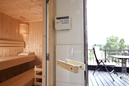 a sauna with a table and a chair on a deck at Störtebeker 7 - STRANDKORB in Kellenhusen