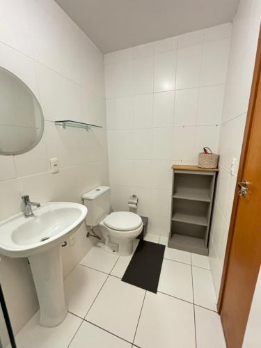 a white bathroom with a toilet and a sink at Vista inesquecível para o mar homeclub BetoCarrero in Penha